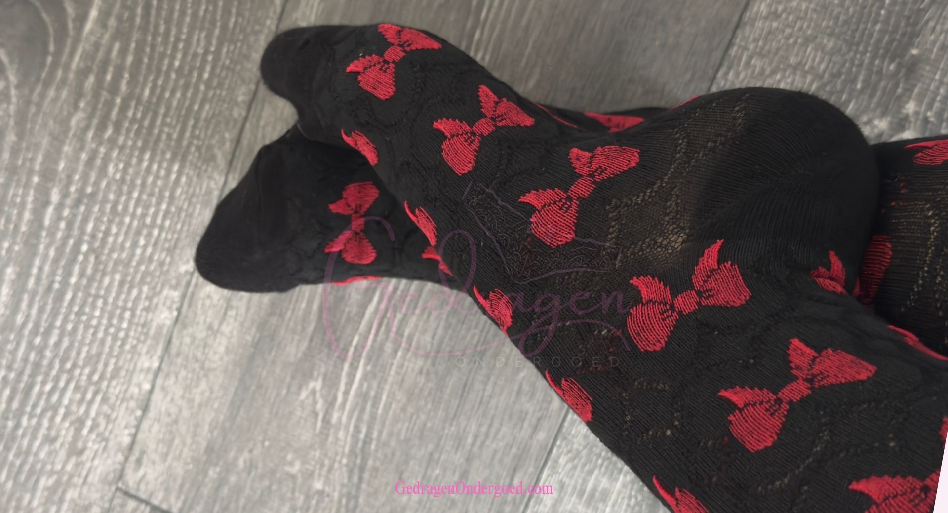 Sokken gedragen om voeten zwart met rode strikjes liggende op de grond