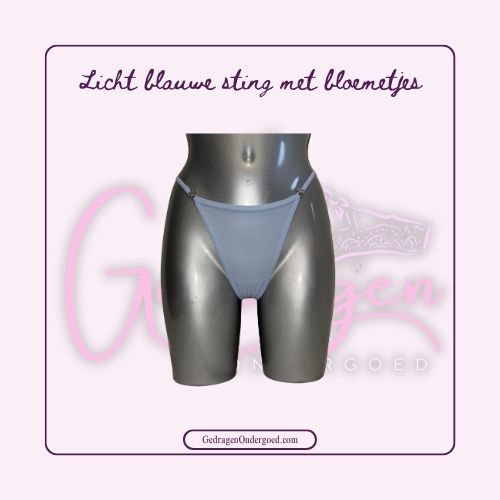 Voorkant van een licht blauwe string met kleine sterretjes in de band van gedragen ondergoed gepresenteerd op een paspop