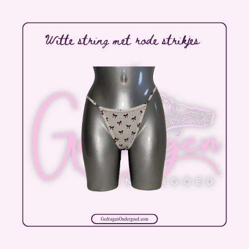 Stoffen witte string met rode strikjes en zilveren metalen strikjes in de band gedragen door gedragen ondergoed gepresenteerd op een paspop