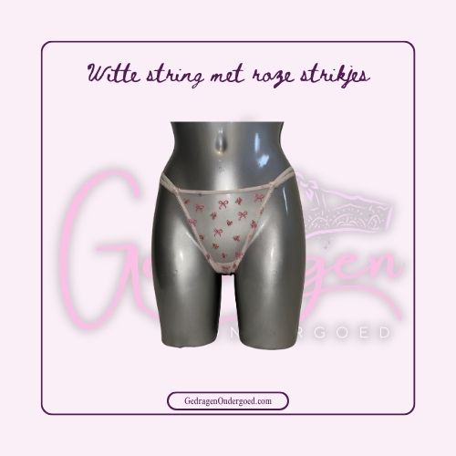 Witte doorschijnende string met speelse genaaide strikjes gedragen door gedragen ondergoed gepresenteerd op een pop 